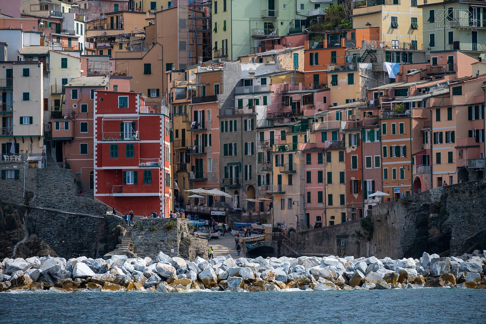Riomaggiore Riomaggiore is the southernmost village. It is deeply incised between the hills, on which terraces have been laid out for agriculture. The houses have the typical Ligurian colors (red, pink, ochre) and lean against the slope. Riomaggiore has about 2,000 inhabitants, making it the largest village together with Monterosso. The village dates back to the twelfth century. Stefan Cruysberghs